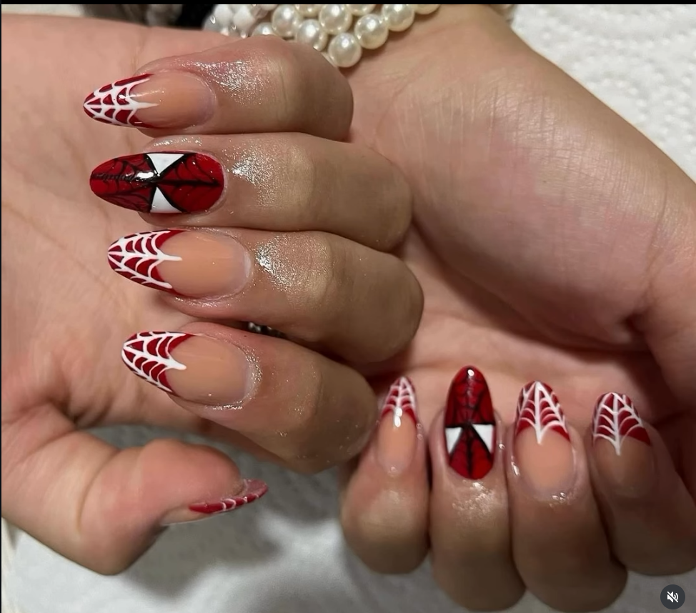 Nail art con diseño telaraña y tonos rojos